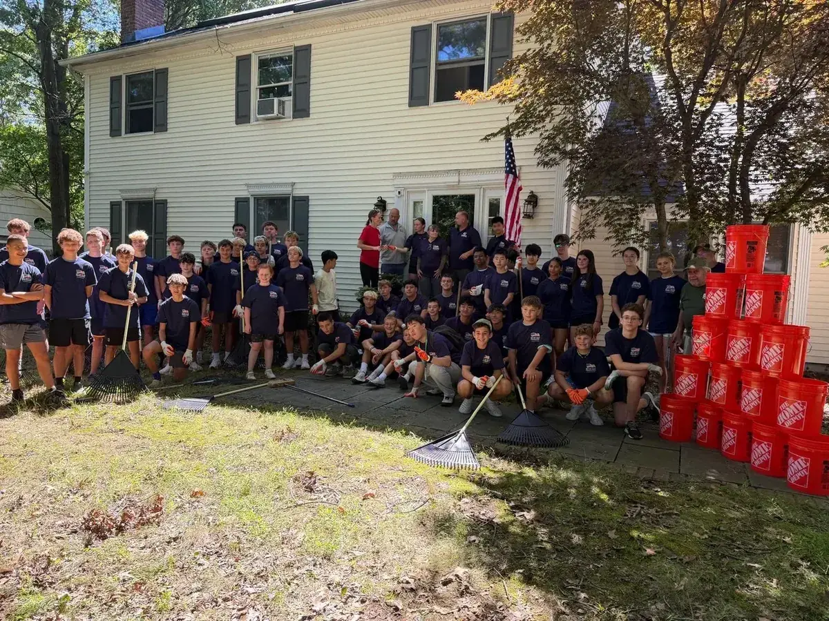 More than 50 student volunteers who restored a local veteran's yard through Youths Helping Heroes at Home